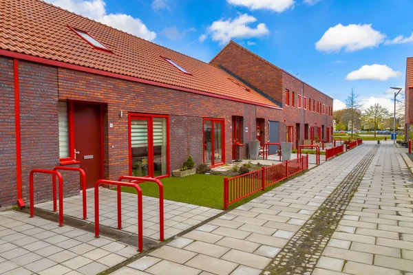 茶色のれんが造りの家と赤い要素新しく建てられた近代的な通り — ストック写真