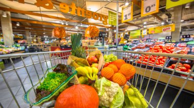 Bakkal dükkanı arabası süpermarkette müşteriler bakış meyve ve sebze bölümünde görüldüğü gibi taze ve sağlıklı gıda ürünleri ile dolu