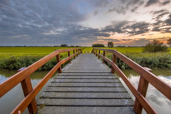 Holzbrücke Über Kanal Landwirtschaftlicher Landschaft Gegen Schönen Farbigen Sonnenuntergang — Stockfoto