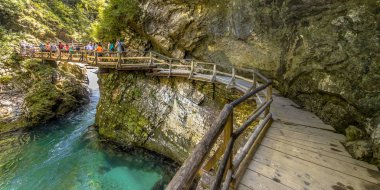 Soteska vintgar gorge güneşli günde tahta Nehri boyunca kayalık yüzündeki üzerinde yürüyen turist