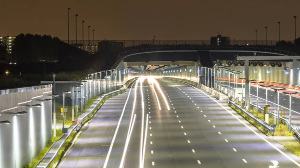 高速公路与隧道入口在晚上与模糊的汽车灯由长时间曝光 — 图库照片