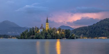 Şimşek ve gök gürültüsü, Slovenya, Avrupa ile St Mary Kilisesi ve zemin fırtınalı gökyüzü altında dağlarda Lake Bled