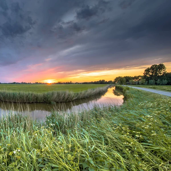 川風景のワイド アングル ビューはオランダ フローニンゲン州フラット農業景観の夕日曲げる — ストック写真