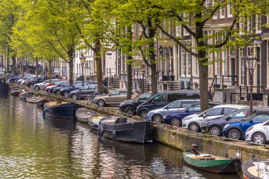 Amsterdam Cannal Sokağı tarihi evler tekneler ve park etmiş arabaların