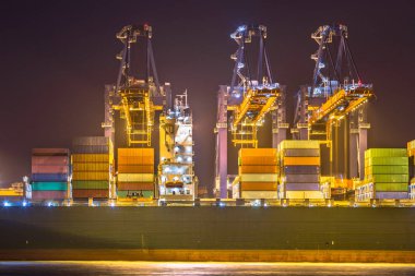 Işıklı kargo gemisi gemi geceleri Rotterdam Maasvlakte konteyner terminali karanlıkta yükleniyor. Hollanda