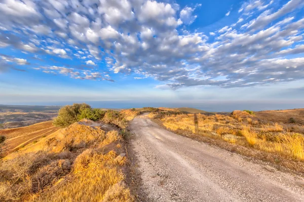 Rocky Road via heuvelachtige mediterrane landschap op het eiland-o — Stockfoto