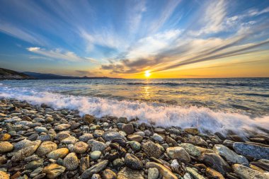 Akdeniz dalgaları Farinole Cap Corse, Korsika, Fransa yakınlarındaki çakıl taşlı plajda kırılıyor