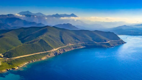 セーリングボートと青い地中海のコルシカ島の海岸線に沿って道路の空中ビュー — ストック写真