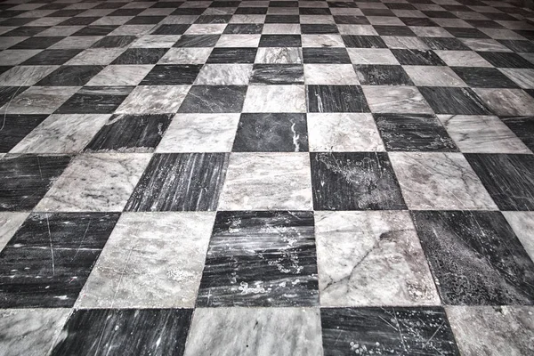 Aged squared tiled white and black marble texture floor background.