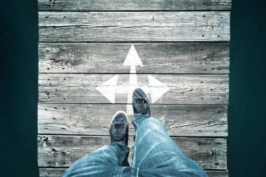 Boyalı beyaz ok kavşak işareti, kullanılan bakış açısı Perspektif ile dar ahşap köprü yürüyüş ve geçiş bir adam yaşlı.