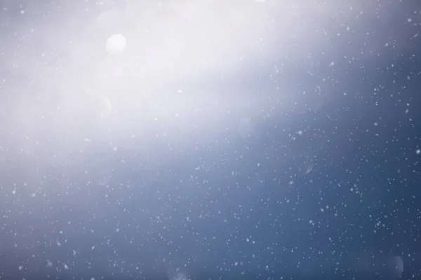 Blue shiny sky with realistic snowflakes copy space background