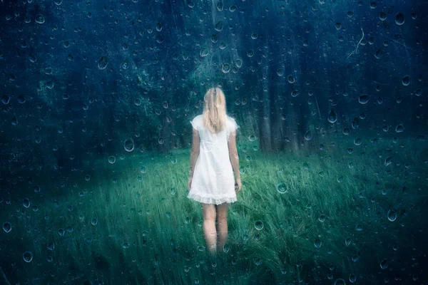 森の背景を持つ牧草地で悲しい女性のバックビュー 雨滴効果 — ストック写真