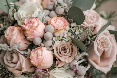 Wedding bouquet in shades of dusty rose, white, green, beige, pink and purple. Beautiful and delicate bridal bouquet close up with diamond engagement ring. clipart