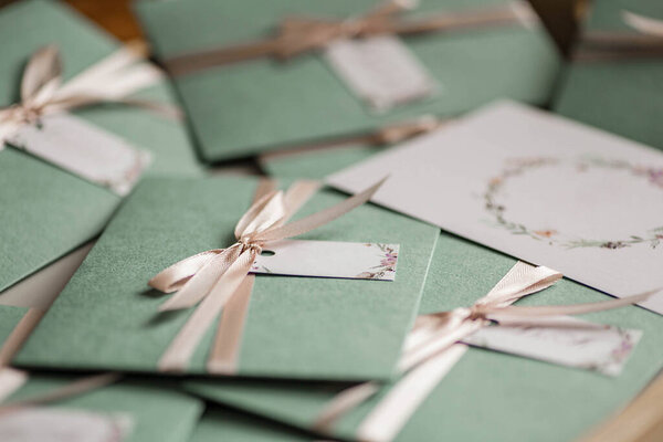 Delicate green envelopes with soft pink bows. Wedding invitation cards. Autumn Wedding Invitation.