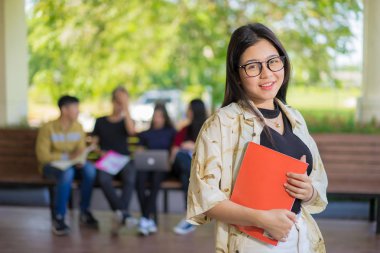 Eğitim ilk, güzel bayan üniversite öğrencisi kitaplarını gülümseyerek mutlu bir oditoryum insanlar eğitim yüksek okulu programı akıllı genç kavramı kopya alanı öğrenme ayakta tutan