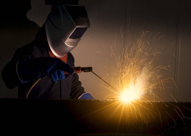 Fabrikadaki sanayi işçisi kaynaklarını kapatıyor.