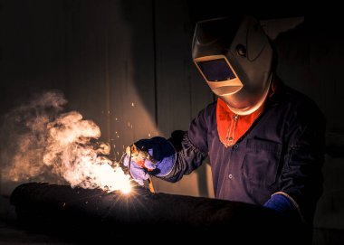 Fabrikadaki sanayi işçisi kaynaklarını kapatıyor.