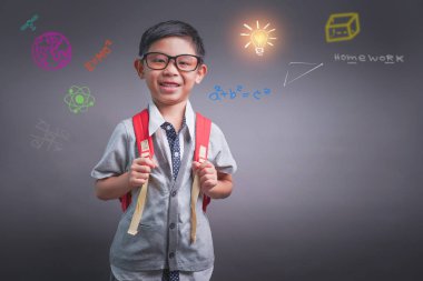 Neşeli küçük boy gülümseyerek büyük sırt çantası ile. Kameraya bakıyor. Okul kavramı. Okula dönüş