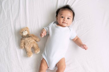 Yatak odasında, bebek çocuk beyaz güneşli yatak, yatak, çocuk odası için küçük çocuklar, tekstil, rahatlatıcı ve çocuklar için yatak takımları yeni doğan çocuk üzerinde tarama Bebek portresi