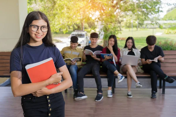 Eğitim ilk, güzel bayan üniversite öğrencisi kitaplarını gülümseyerek mutlu bir oditoryum insanlar eğitim yüksek okulu programı akıllı genç kavramı kopya alanı öğrenme ayakta tutan