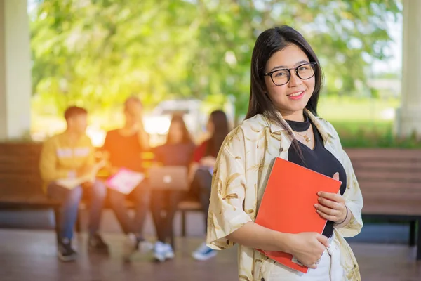 Eğitim ilk, güzel bayan üniversite öğrencisi kitaplarını gülümseyerek mutlu bir oditoryum insanlar eğitim yüksek okulu programı akıllı genç kavramı kopya alanı öğrenme ayakta tutan