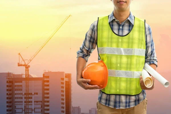 Engineer or Safety officer holding hard hat with the mobile crane machine is background in construction site, Civil construction engineering concept