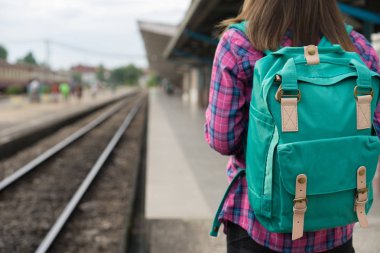 Gezgin kadın yürüyüş ve beklediği Tren demiryolu platformu, güneş ışık parlama, seçici odak