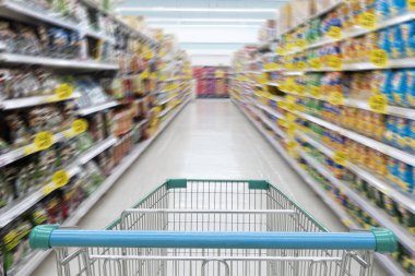 Süpermarket koridor boş mavi alışveriş sepeti ile müşteri ile arka plan bulanıklık