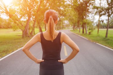 Arkadan görünüşü sabah, insanlar ve spor kavramı, seçici odak de yol çalışan genç fitness kadın