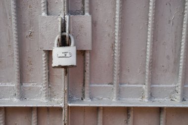 Kapıda eski kilit var. Eski bir çiftlik evinin kapısına kilit vurun. Gerçek köy tarzı. Yakın plan. Kilide odaklan