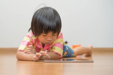 Evde dijital tablet ile oynayan çocuk portresi.