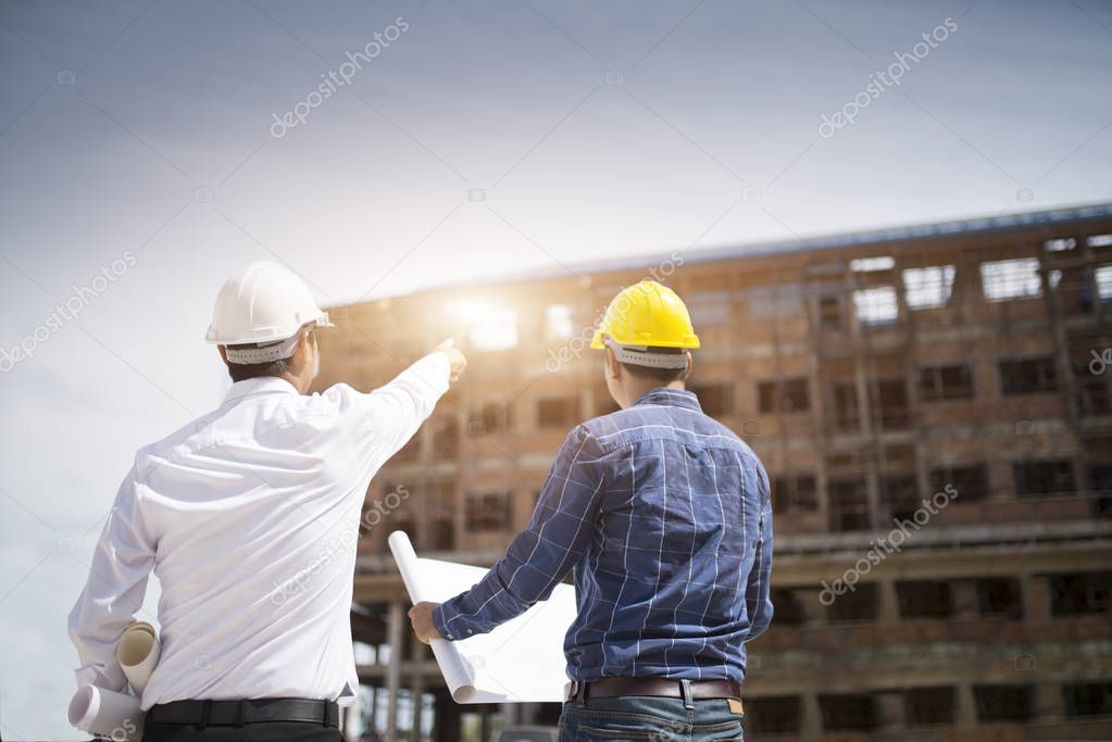 Construction engineers discussion with architects at construction site or building site of highrise building