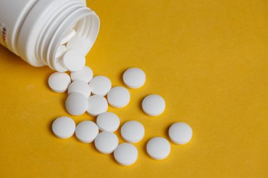 Açık sarı renkli beyaz plastik hap şişesinde dışarı dökülmesini beyaz hap