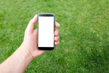 El arka plan gür yeşil çim erkeklerde telefon. Mockup tasarım için