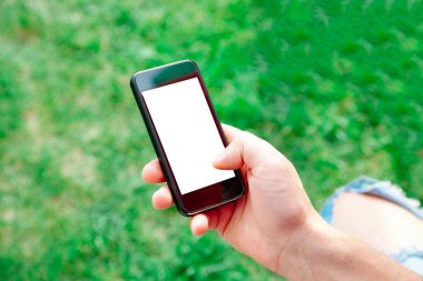 El arka plan gür yeşil çim erkeklerde telefon. Mockup tasarım için