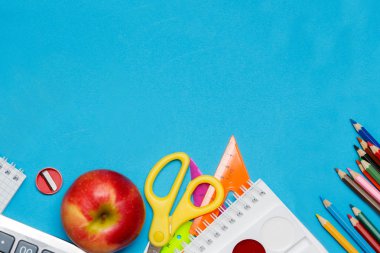 Mavi bir arka plan üzerinde okul aksesuarları. eğitim kavramı