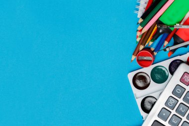 Mavi arka plan Tasarımlarınız için hazır üzerinde okul malzemeleri. Üstten görünüm