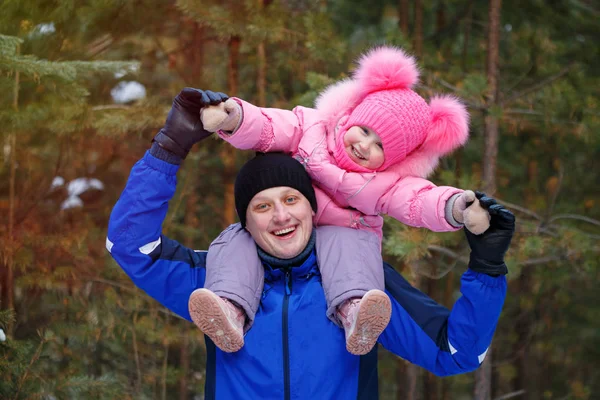 Petite fille assise sur les épaules de son père dans la forêt d'hiver — Photo