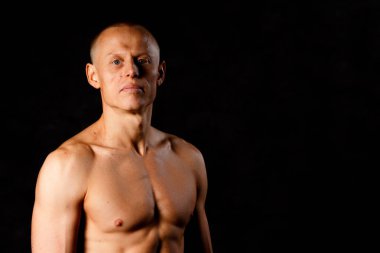 Karanlık bir arka plan üzerinde bir kas dövmeli adam.