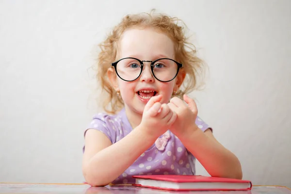 Egy kis vicces lány a szemüveg is el fogod olvasni egy könyvet — Stock Fotó