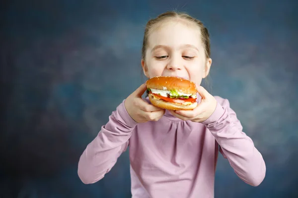 Burger yemek oldukça Amerikan küçük kız. Sağlıksız yeme kavramları