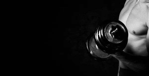 Primo piano di un uomo muscoloso pronto ad allenarsi. Parte del corpo dell'uomo con manubri in metallo su sfondo scuro — Foto Stock