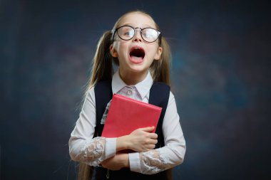 Açık ağız ile şirin kız öğrenci kitap sıkı tutun