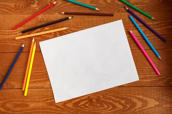 Blanco lijst van papier en verschillende gekleurde potloden — Stockfoto