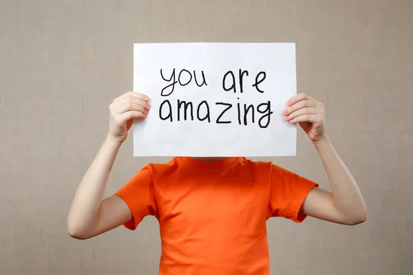 Elinde bir kağıt parçası olan küçük bir kız. Onun önünde inanılmazsın. Kağıt siyah el yazısıyla beyaz..