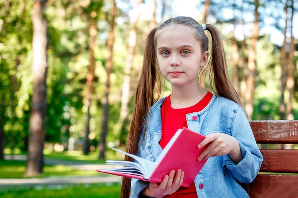 Kaukaska Dziewczynka Siedzi Ławce Podczas Czytania Książki Parku Koncepcja Edukacji — Zdjęcie stockowe