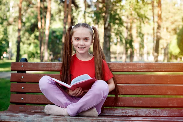 Портрет Милой Улыбчивой Маленькой Девочки Сидящей Деревянной Скамейке Парке Открытой — стоковое фото