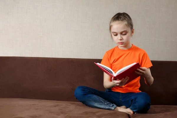 Linda Niña Sentada Sofá Leyendo Libro Aprendizaje Distancia —  Fotos de Stock