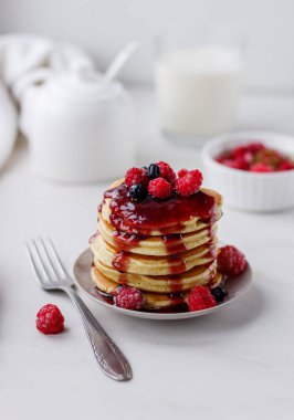 Beyaz arka planda ahududu ve meyve sosu ile lezzetli krep ile plaka. Üstteki görünüm kopyası alanı