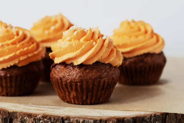 Frisch und lecker mit orange Zuckerguss Cupcakes auf weißem Hintergrund — Stockfoto